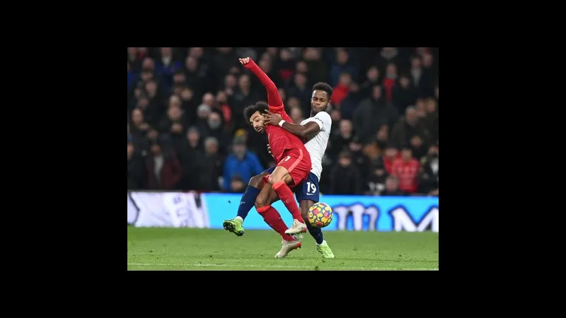 Cầu thủ Tottenham với áo màu trắng đang tấn công vào khung thành của Liverpool với áo màu…